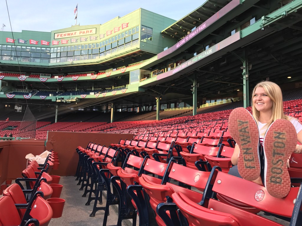 Kailee at Fenway with her feet up and shoes that say "Fenway" and "Boston"