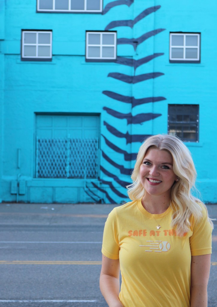 Kailee in front of blue baseball wall.